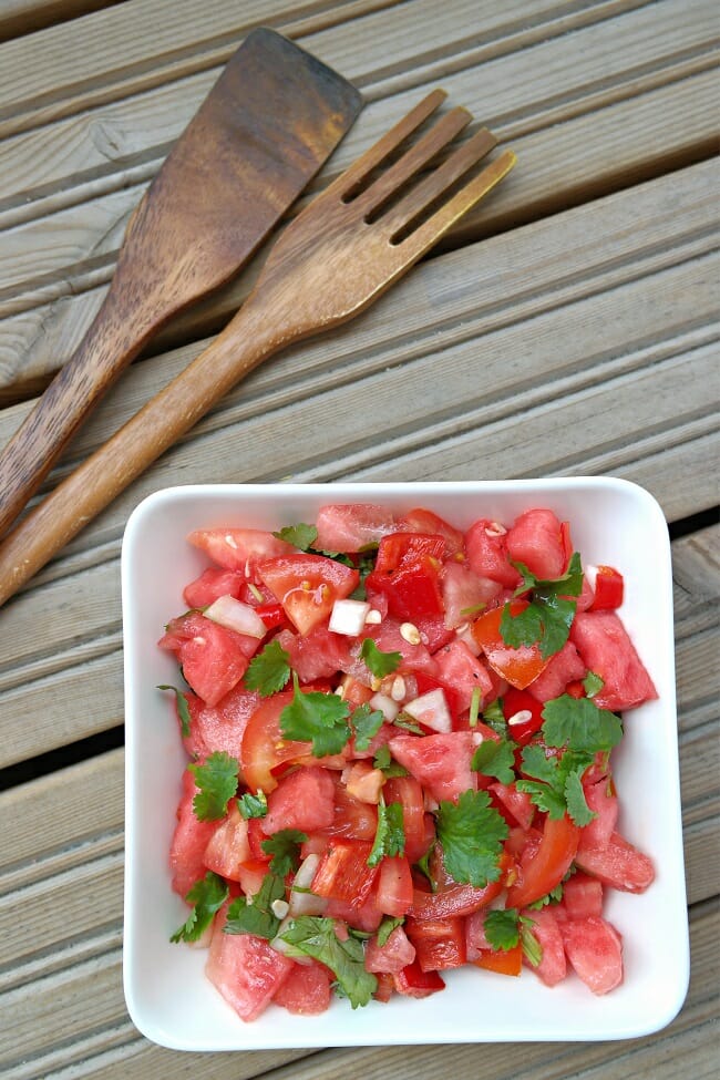Tomaatti-vesimelonisalaatti piristää punaisella värillään. Tämä raikas salaatti kannattaa viimeistellä rapeilla siemenillä.